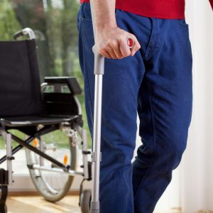 Horizontal view of a disabled man on crutches