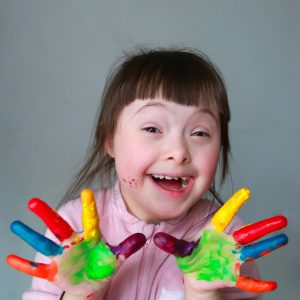 Cute little girl with painted hands. Isolated on grey background.